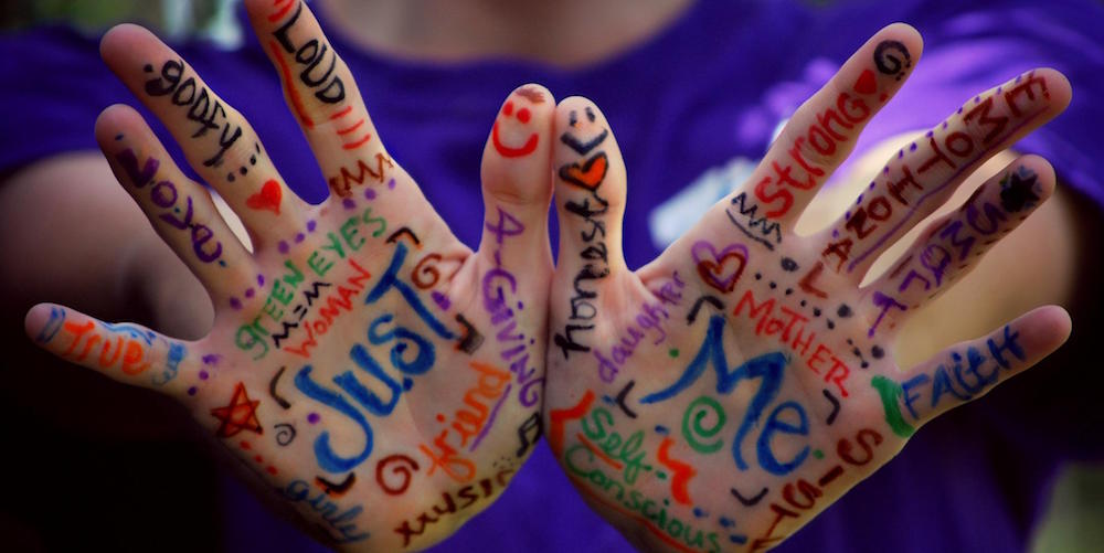 Palms of hands with all sorts of words written on them.